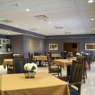 A spacious and welcoming dining area featuring elegantly set tables and comfortable seating.