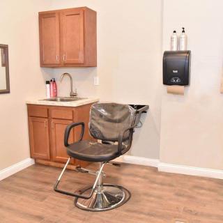 A salon interior featuring a barber chair and sink setup.