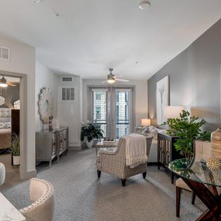 A modern living room with neutral colors, stylish furniture, and decorative plants.