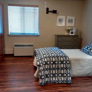 A cozy bedroom with a single bed, featuring modern decor and wooden flooring.