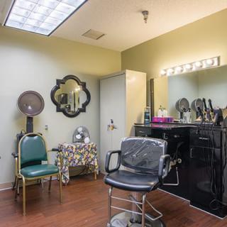A cozy hair salon interior with a styling chair and vanity mirror.