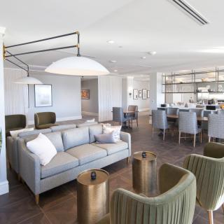 A modern living room with contemporary furniture and an open dining area.