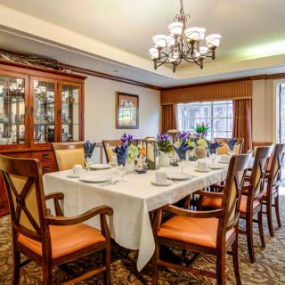 An elegantly decorated dining room with a large table set for a formal gathering.