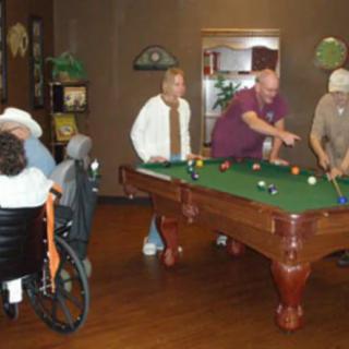 A group of people playing billiards in a recreational setting.