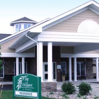 The front entrance of a residential building with a sign reading 'The Willows'.