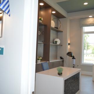 A modern office interior with a desk and decorative shelves.