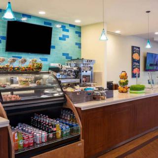 A modern cafe interior with a well-stocked display case and beverage cooler.
