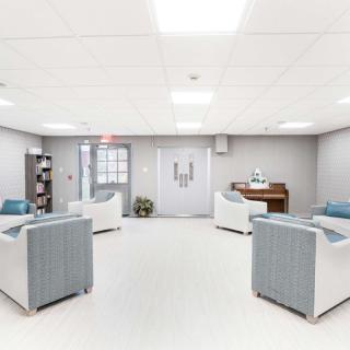 A modern waiting room with comfortable seating and a piano.