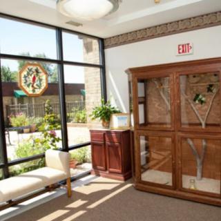 A bright lobby with wooden furniture and large windows letting in sunlight.