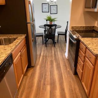 A modern kitchen featuring granite countertops and a dining area.