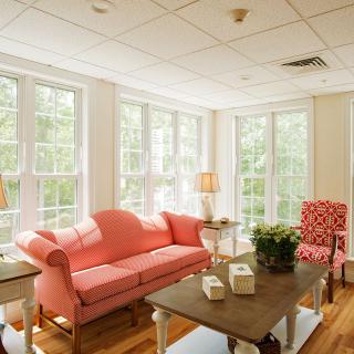 A bright and cozy living room with a pink sofa and large windows.