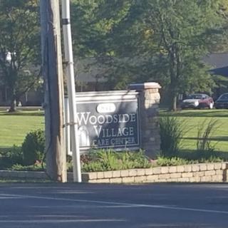 Entrance sign for Woodside Village, a residential community.