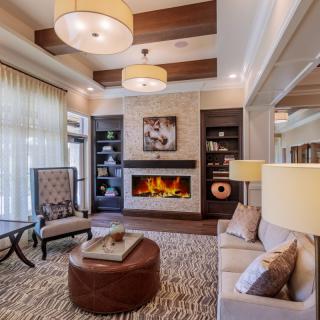 A modern and cozy living room featuring a fireplace, elegant furniture, and soft lighting.