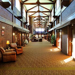 A spacious hotel lobby featuring wooden beams and cozy seating areas.