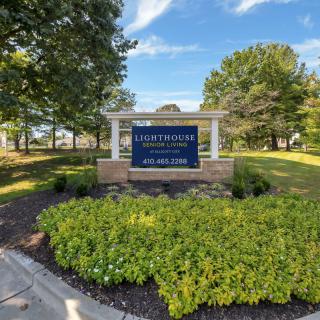 Entrance sign for a residential community surrounded by lush landscaping and trees.