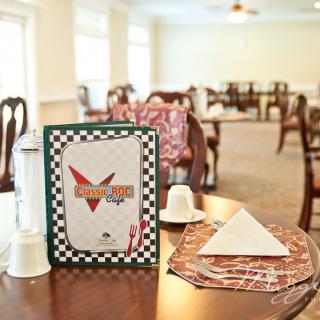 A cozy cafe interior with neatly arranged dining tables and a prominently displayed menu.