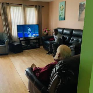 Two people watching TV in a cozy living room.