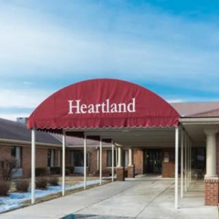 The entrance to a building with a red awning labeled 'Heartland'.