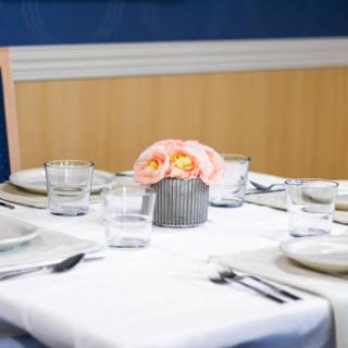 A beautifully arranged dining table featuring elegant glassware and a floral centerpiece.