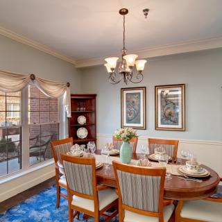A cozy dining room with a wooden table, chairs, and elegant decor.