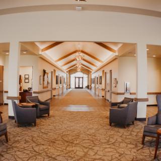 A modern hallway with seating areas and decorative lighting.