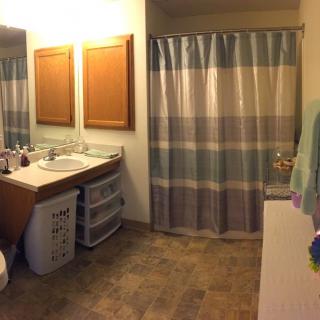 A well-organized bathroom with a double sink, storage drawers, and a striped shower curtain.
