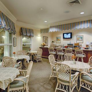 A cozy cafe interior with wicker furniture and a bar counter.