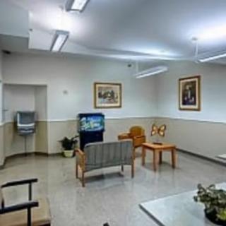 A waiting room with seating, a television, and framed artwork on the walls.