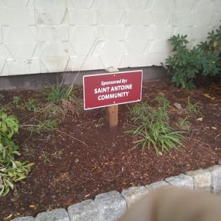 A sign indicating sponsorship for a community garden.