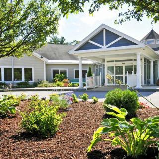 A well-maintained garden leads to the entrance of a modern building.
