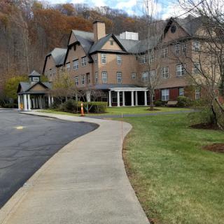 A picturesque view of a building accompanied by a winding pathway and surrounding greenery.