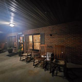 A serene nighttime view of a porch featuring rocking chairs, inviting relaxation.