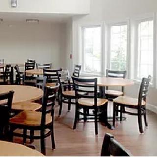 A bright, empty dining area with multiple tables and chairs.