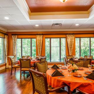 A beautifully decorated dining room with multiple set tables and large windows.