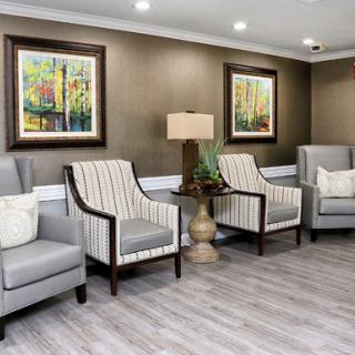 A cozy and modern seating area featuring striped chairs, a lamp, and vibrant artwork.