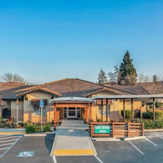 A modern commercial building with a welcoming entrance and landscaped surroundings under a clear blue sky.