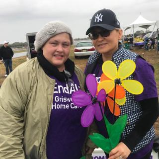 Participants enjoying a community event, showing support with colorful flowers.