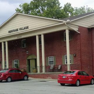 A view of the residential structure 'Huntington Village' featuring a columned entrance and red brick exterior.