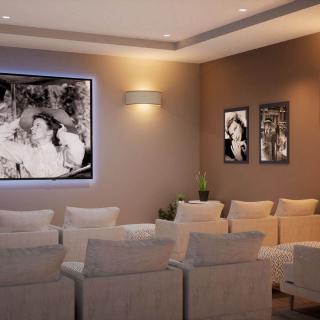 A cozy home theater with comfortable seating and framed black-and-white photos on the wall.