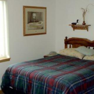 A cozy bedroom with plaid bedding and simple decor.