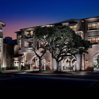 A beautifully lit building at night, surrounded by trees.