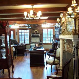 A cozy and elegantly decorated living room featuring wooden beams, a classic fireplace, and stylish furniture.