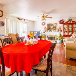 A cozy living and dining area with a red tablecloth and warm decor.