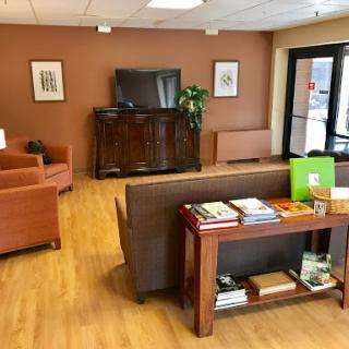 A cozy waiting room featuring comfortable seating, a television, and a selection of magazines.