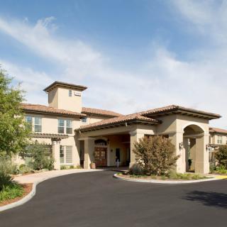 A large residential home with a spacious driveway and landscaped surroundings.