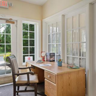 A bright office space with a desk and chair by the window.