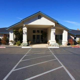 A front view of a building entrance with large columns and a driveway.
