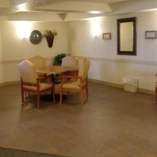 A cozy seating area featuring a table and chairs, complemented by soft lighting and simple decor.
