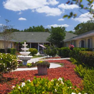 A beautifully landscaped courtyard with a central fountain and vibrant greenery.
