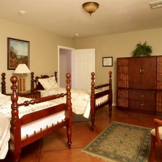 A traditional bedroom with twin beds and wooden furniture.